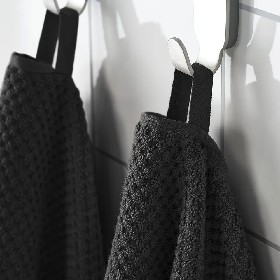 Black towels hang on hooks, soft, absorbent, 100% cotton.