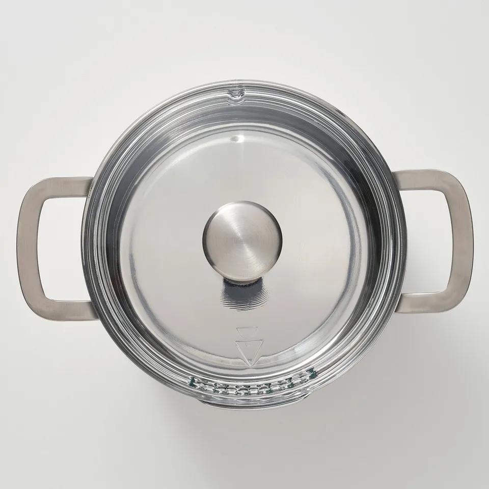Stainless steel pan with lid, sturdy handles, for durability.