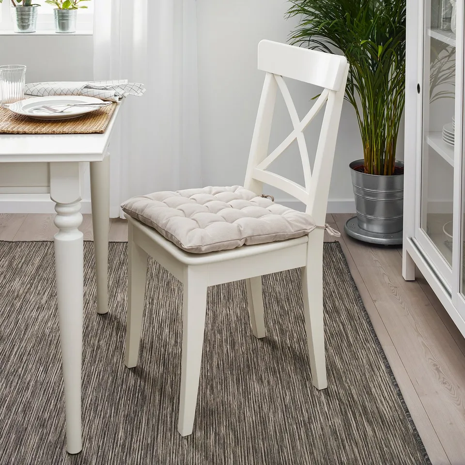 VIPPÄRT chair pad on dining chair. Thick, cushioned. Near dining table, plant.