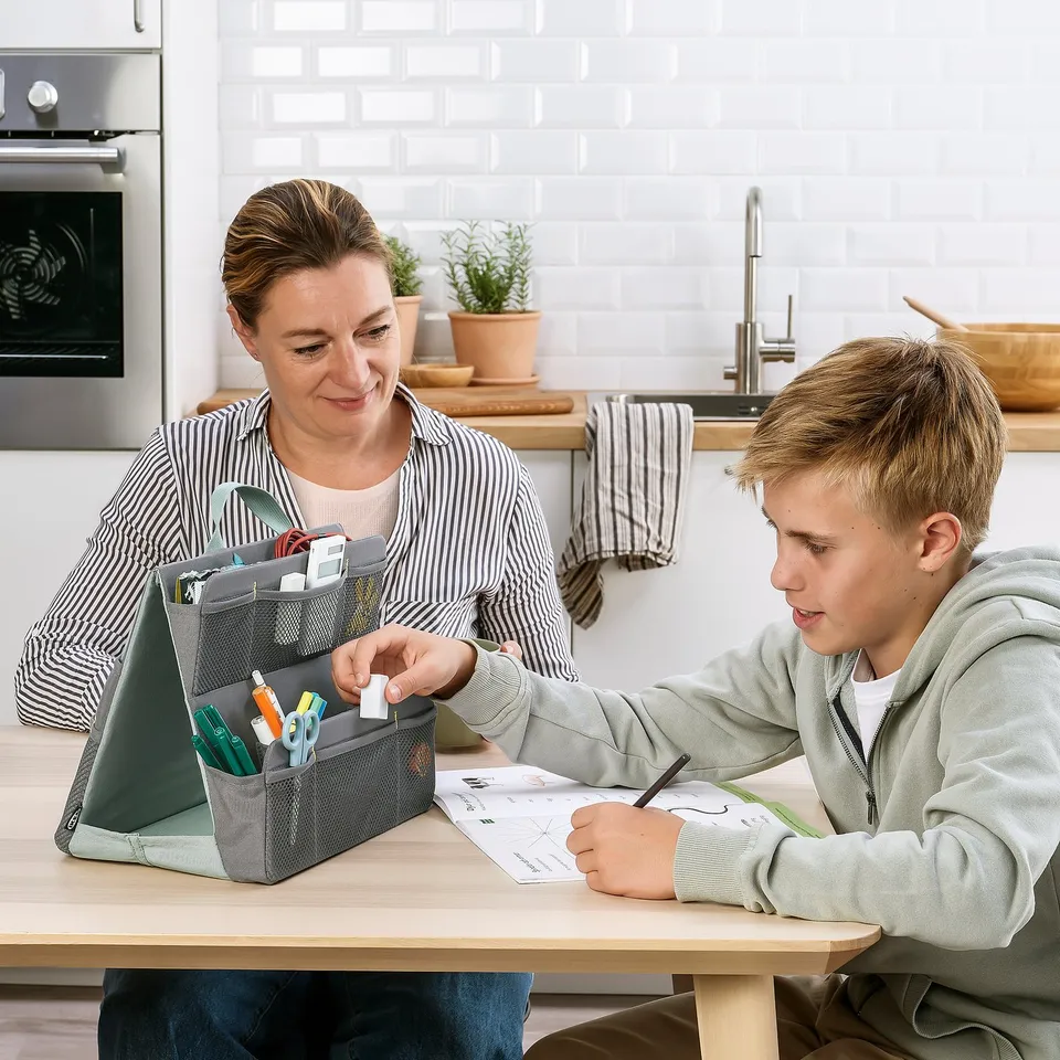 Person and boy studying with ÖVNING organiser and pens on kitchen table.