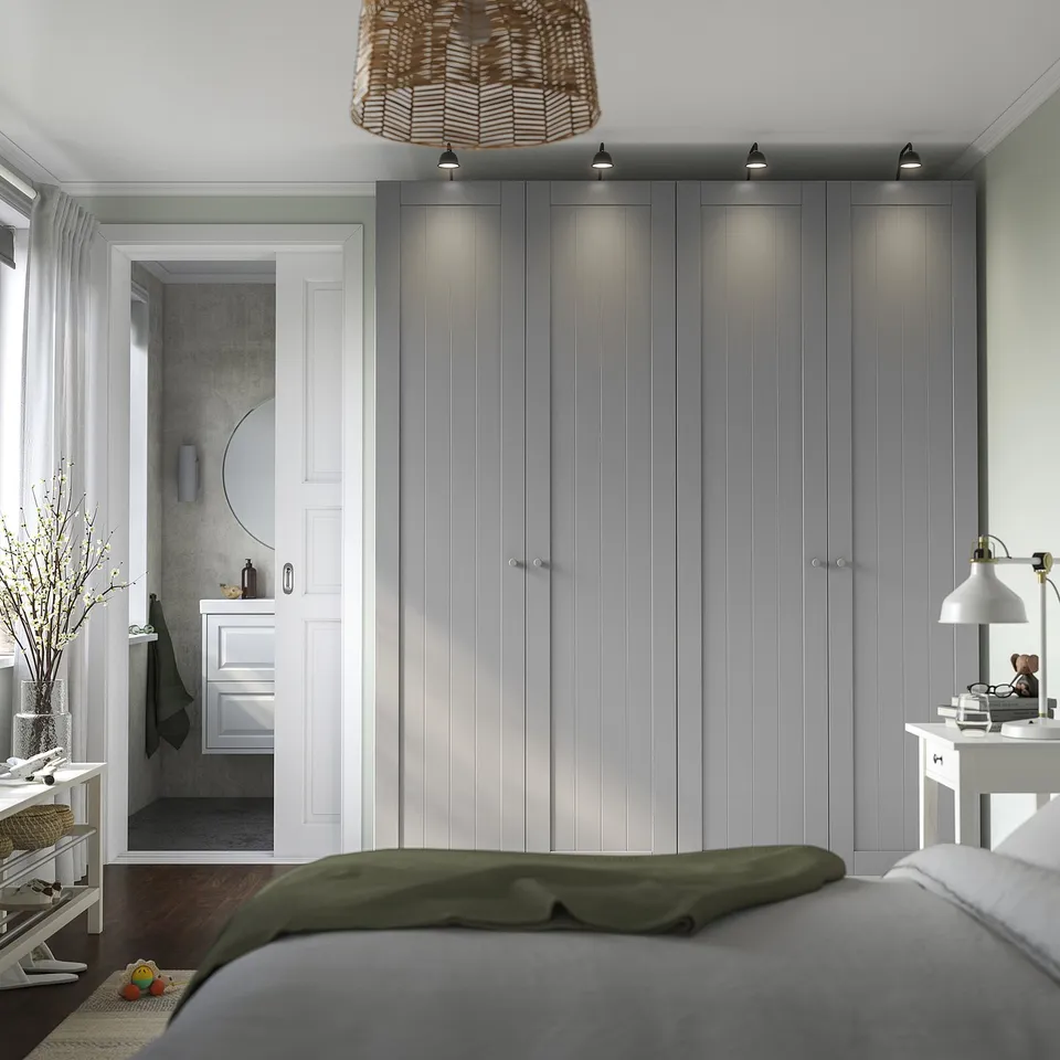 Modern bedroom with grey PAX wardrobe, lighting, and green bedding.