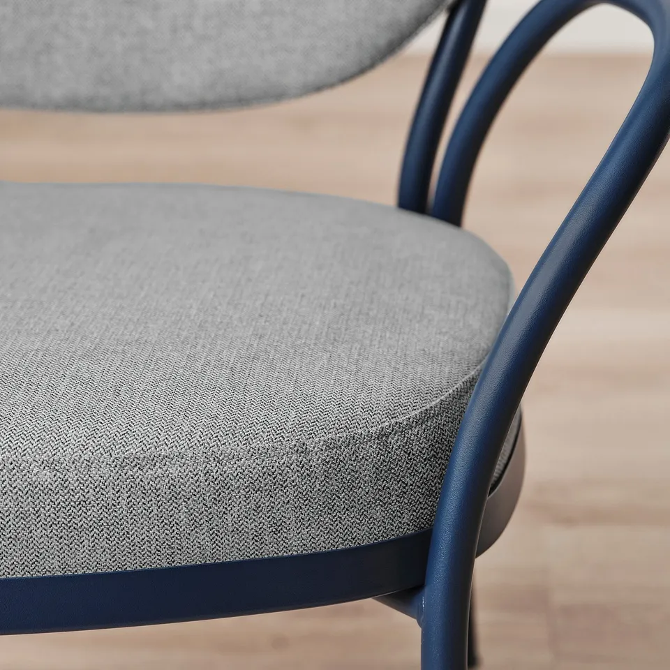 Close-up of ISMANTORP chair, navy frame, grey herringbone seat, showcasing quality bentwood design.