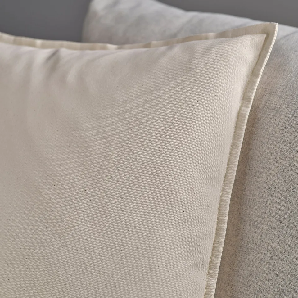 Close-up of soft, beige GURLI pillow with crinkled cotton texture; zip visible.