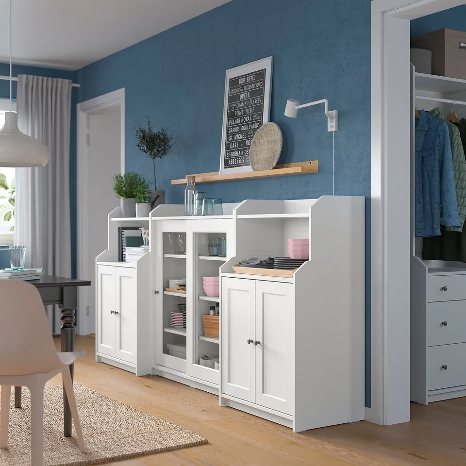 Modern living room featuring white HAUGA storage units with glass doors, showcasing a blend of open and closed storage.