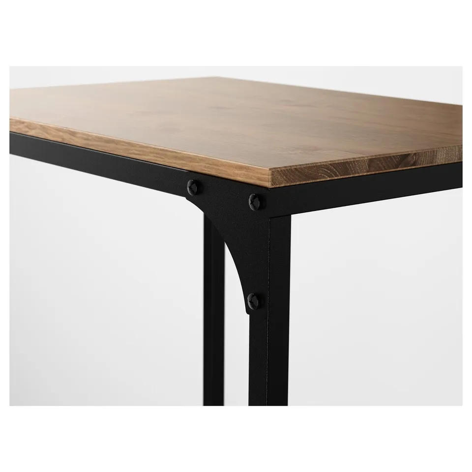 Close-up of rustic table with wooden top and black metal legs.