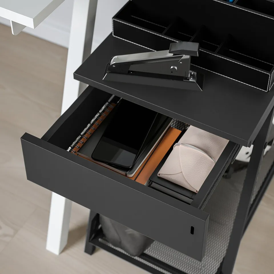 Black TROTTEN storage with drawer holding tablet, wallet, keys. Lockable. Ideal for office/living spaces.