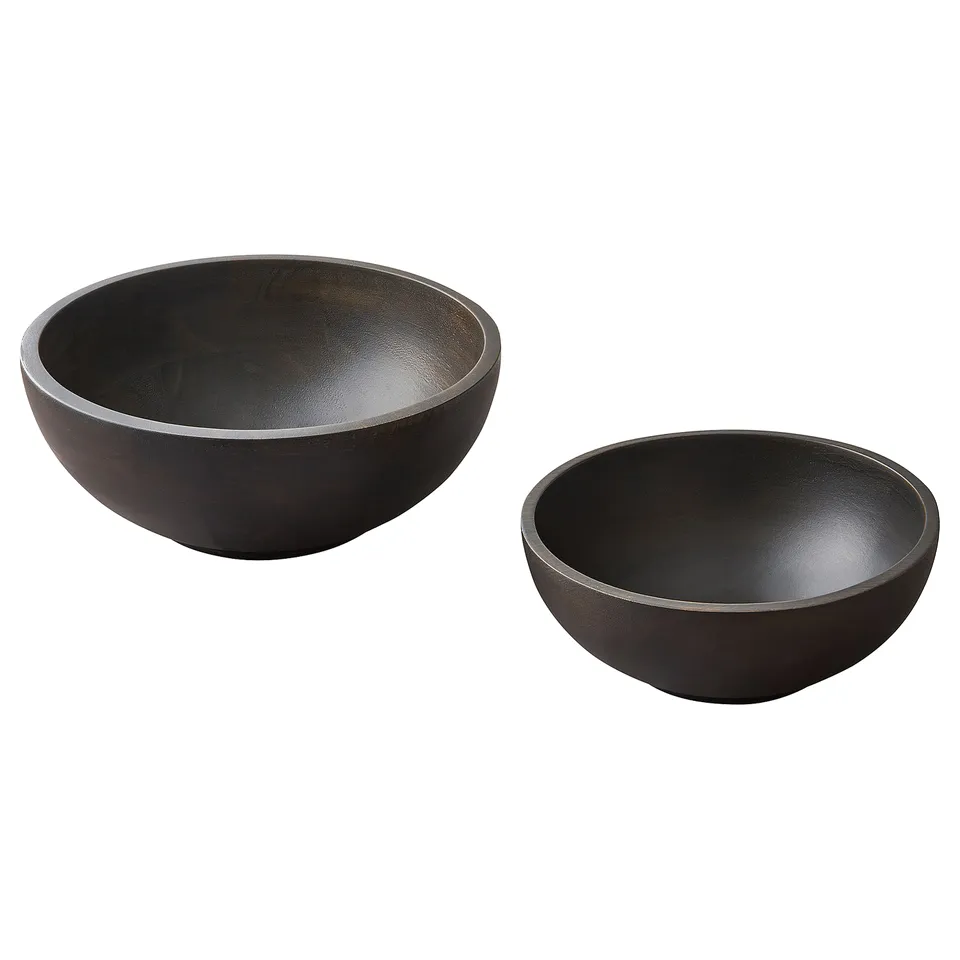 Two black wooden bowls, one larger and one smaller, round shape with smooth edges, simple rustic design, placed side by side.