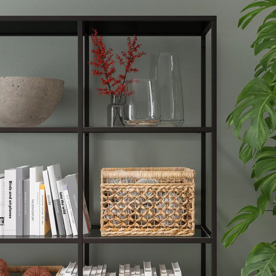 Bookshelf with glass vases and basket. Industrial design with dark metal.
