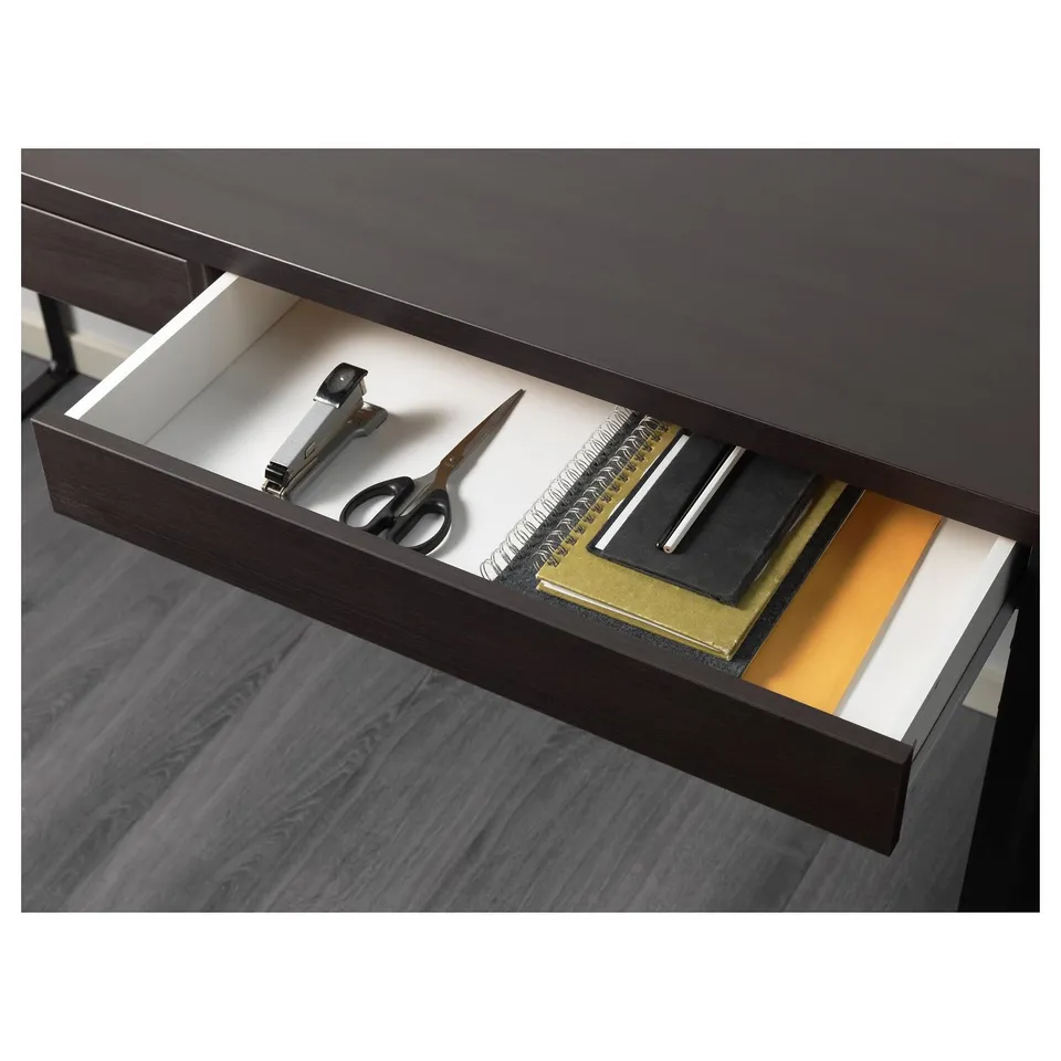 Desk drawer showing stationery, including scissors and notebooks.