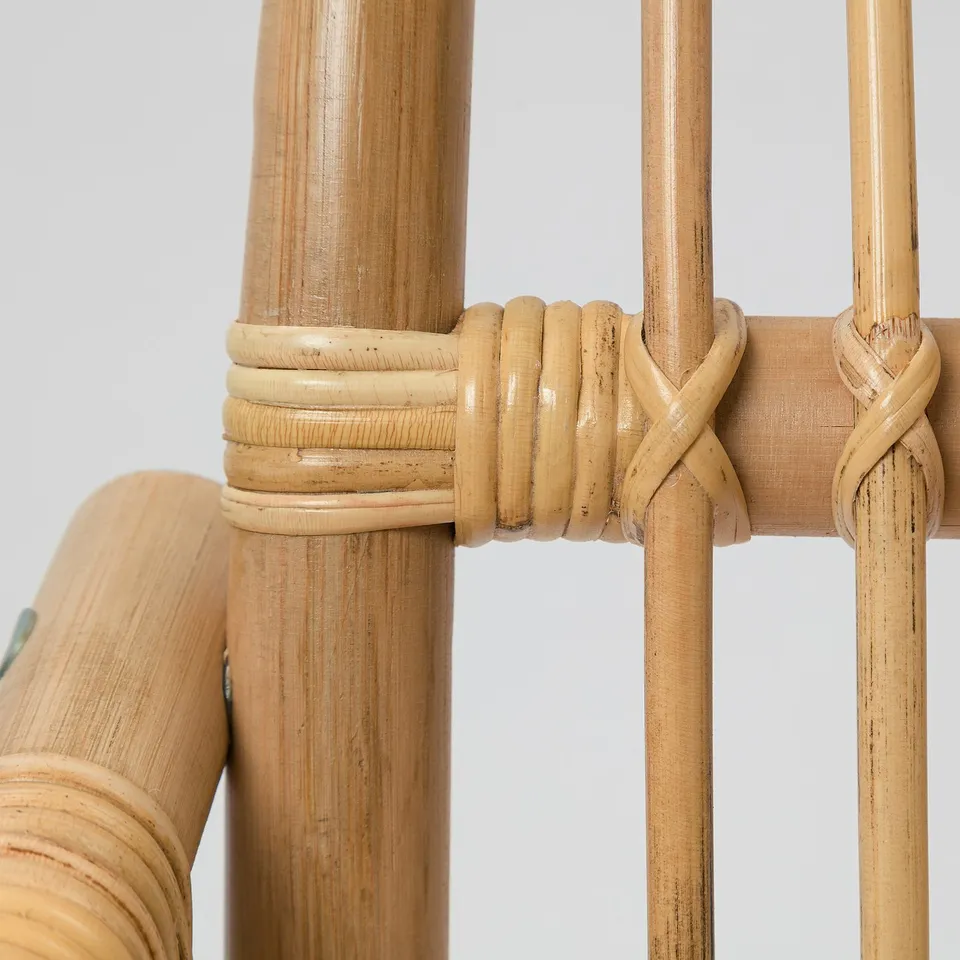 Natural rattan chair detail: intricately woven, smooth finish; expert craftsmanship ensures durability, comfort.