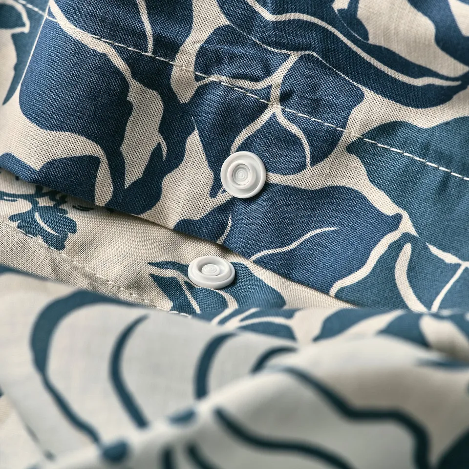 Close-up of PJÄXE duvet set featuring recycled cotton. Shows snap closure and patterned design.