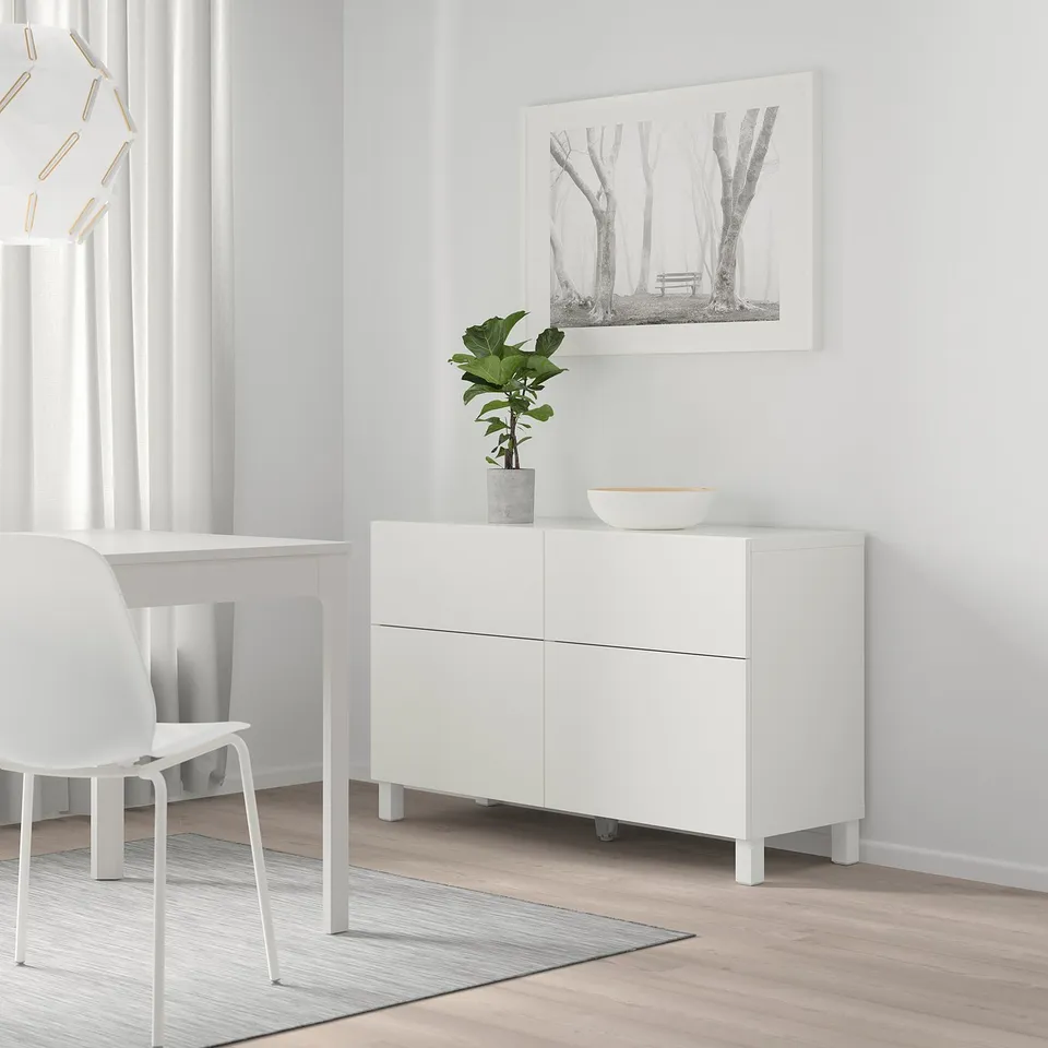 White BESTÅ sideboard with 2 cabinets, drawers, plant, forest photo, minimalist decor.