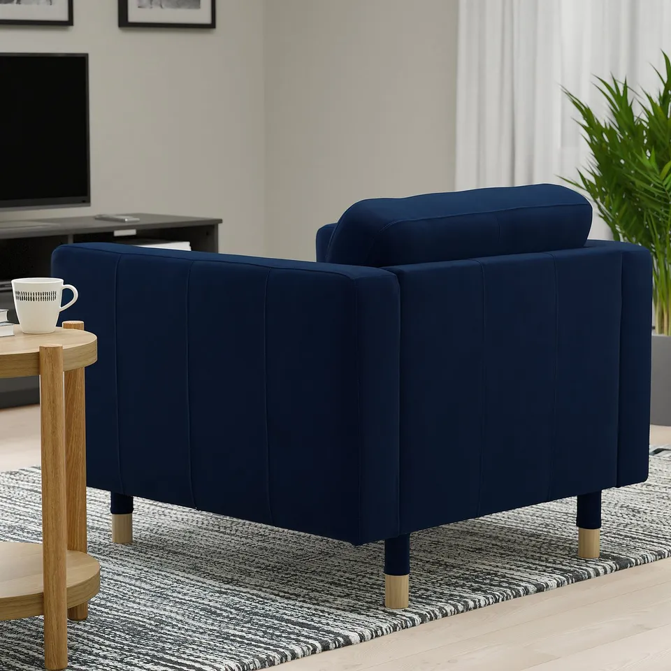 Two blue upholstered armchairs, designed for comfort, with wooden legs, in a cosy living room setting.