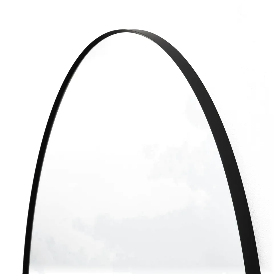Arc-shaped mirror with sleek black frame, reflecting a minimalist design.