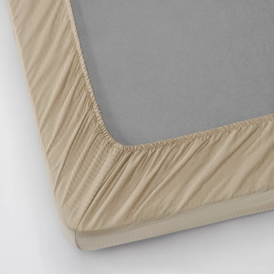 Image shows fitted sheet with elasticized edges on a thick mattress, designed for comfort and stability.