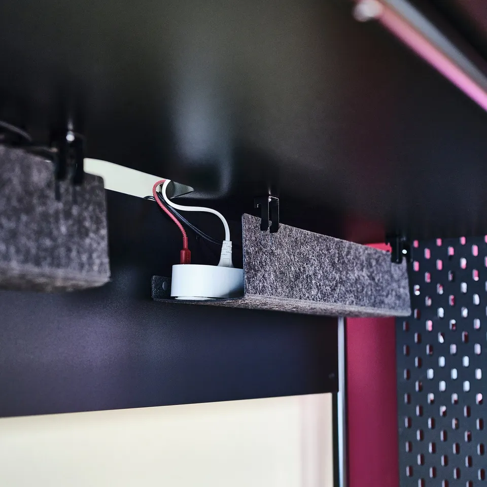 Cable management system: cable clips attached to felt shelf, organising and hiding wires under desk.