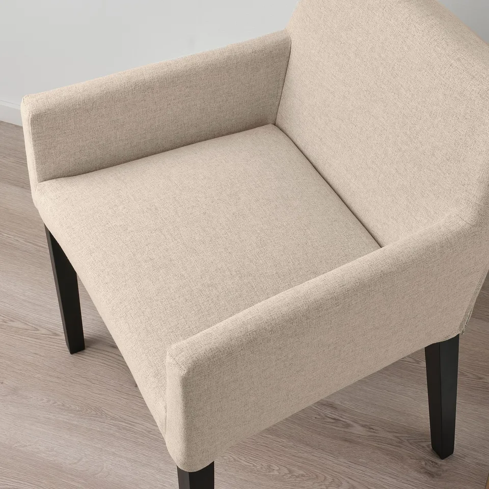 Modern beige armchair with upholstered seat and back, supported by sturdy black wooden legs.