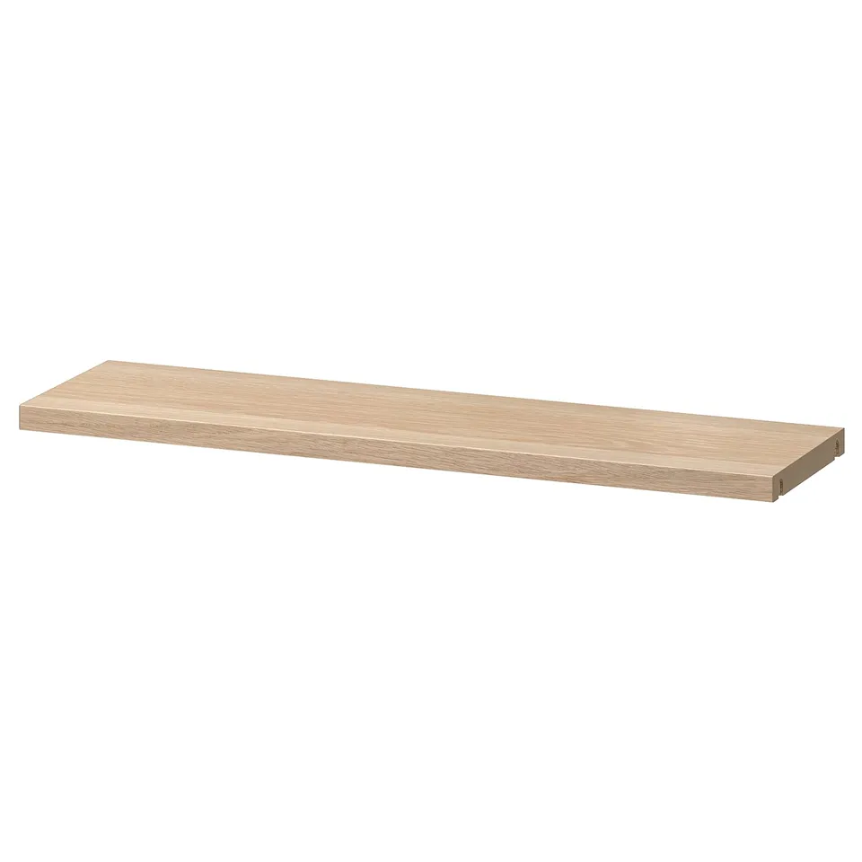 A BESTÅ light brown shelf made of particleboard, smooth and sleek. Its rectangular with clean edges offering simple storage.