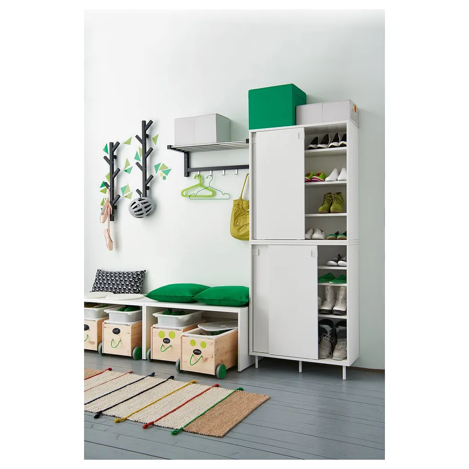 White shoe cabinet with sliding doors & adjustable shelves, green cushion bench, wall coat rack.