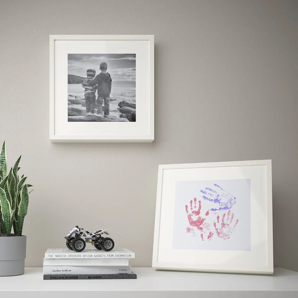 Two framed memories: black & white kids by sea, colourful handprints below. Plant & books complete cosy wall.