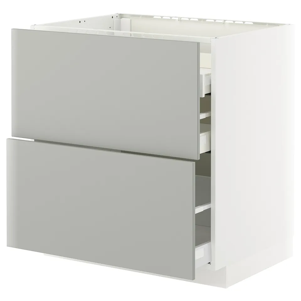 White METOD kitchen unit with light grey drawers and shelves.