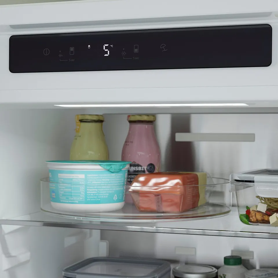 Black fridge display, temperature, and settings panel above two shelves with various food items, including bottles and containers.