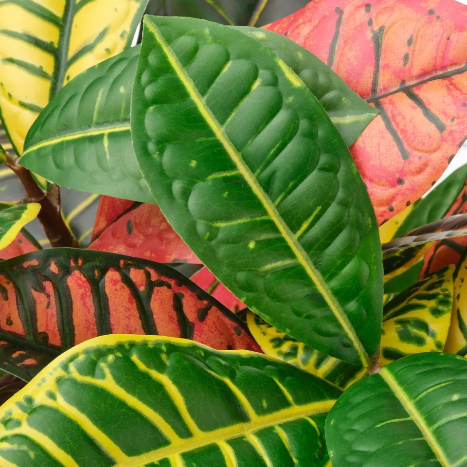 Vibrant, realistic artificial leaves close-up; green and yellow hues, detailed veining.