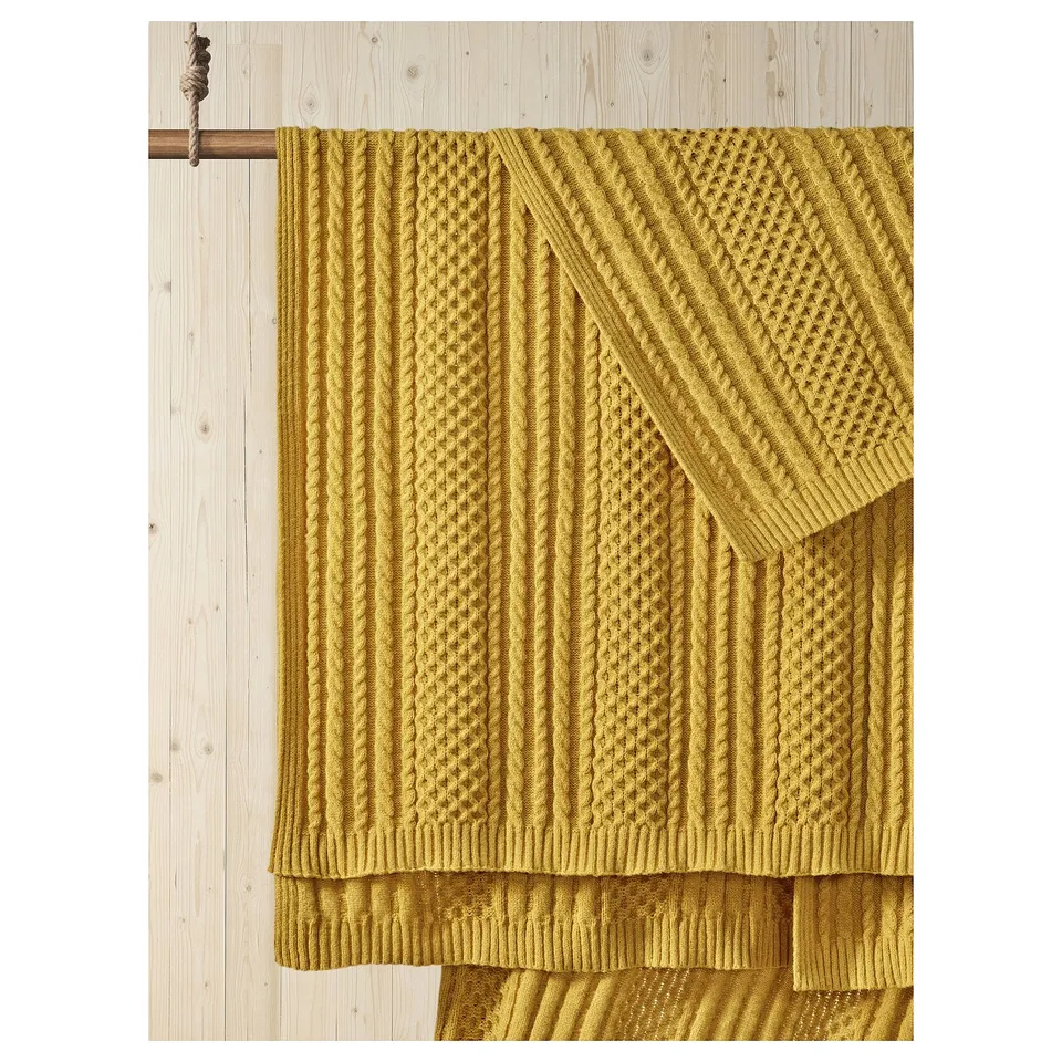 Mustard yellow SÖRBYSKOGEN throw blanket, soft textured knit, machine-washable, 100% recycled polyester.