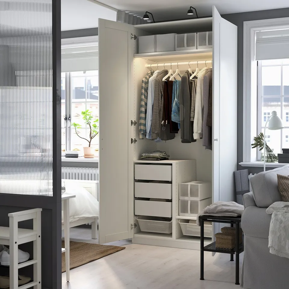 Modern wardrobe with clothes hangers, drawers, and baskets. Interior lighting illuminates the storage space.