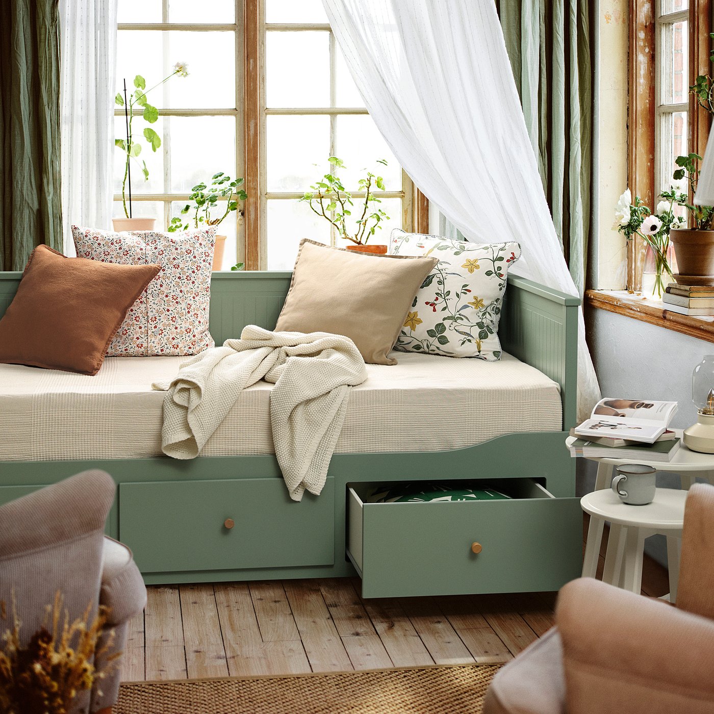 Cosy day-bed with soft pillows and blankets, transforming into a double bed with large storage drawers.