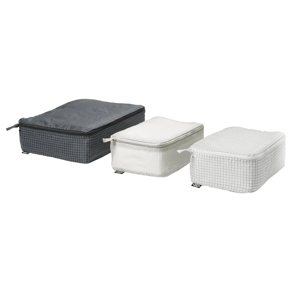 Three packing cubes in grey and white grid design; rectangular, zipped; for organising travel items.