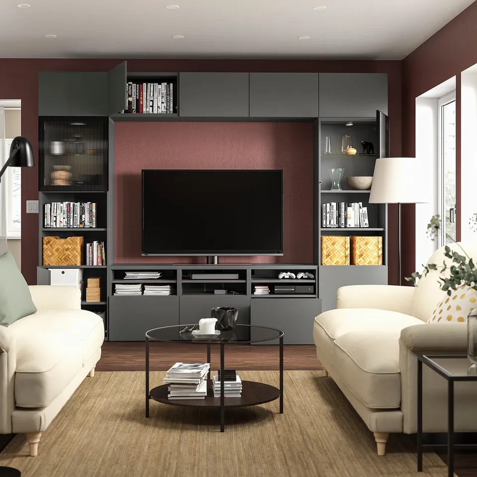 Modern living room with maroon walls, white sofas, large tv on BESTÅ.