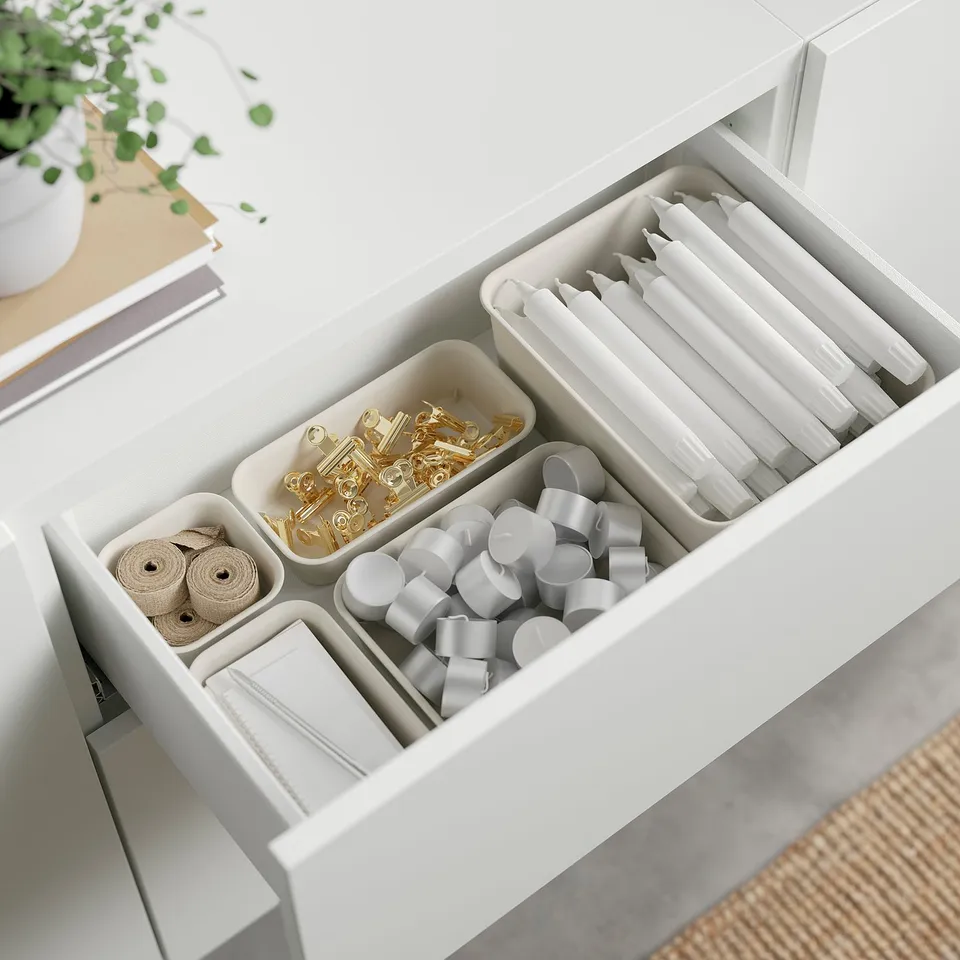 Organised drawer with ribbons, tapes, and office supplies.