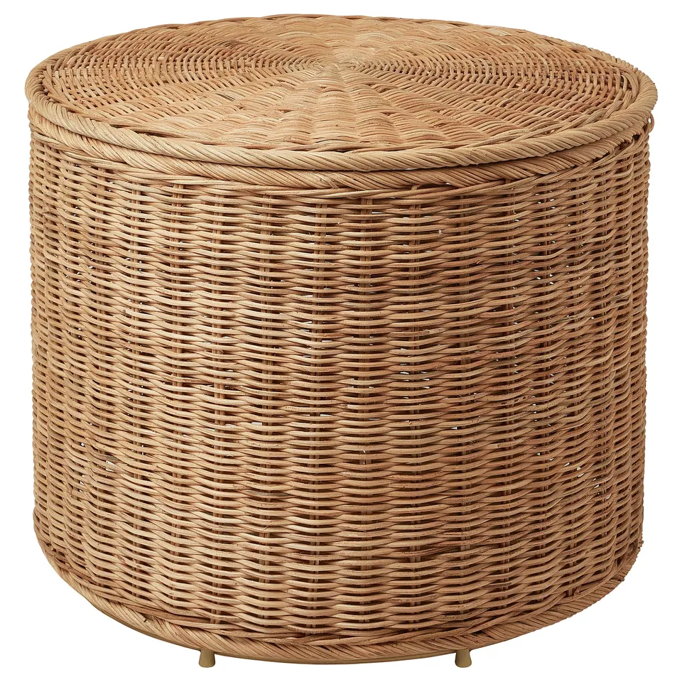 A beige TOLKNING wicker ottoman with a lid for storage.