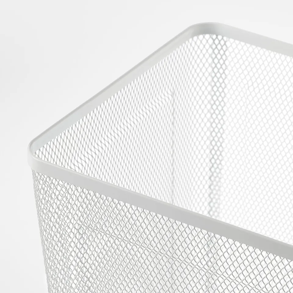 Close-up of a white metal mesh waste basket, showcasing its sturdy and sleek design.