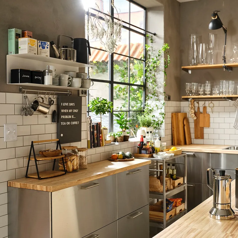 Modern kitchen with stainless steel and wood elements, featuring open shelves, hanging lamps, and a large window.