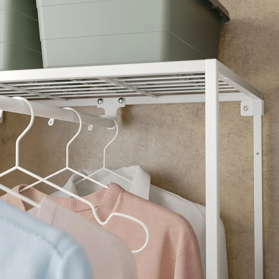 White JOSTEIN closet with clothes, hanging rod, and shelf.