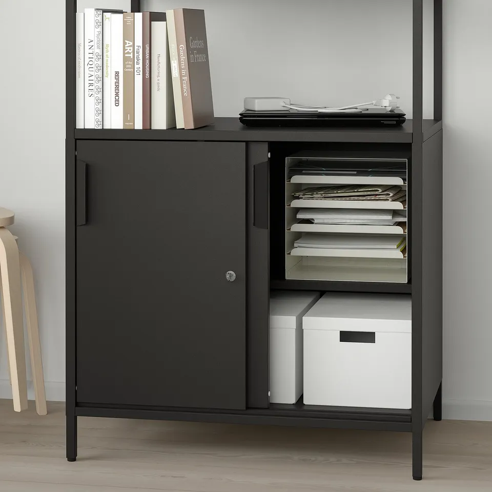 Black storage cabinet with sliding doors, open shelves, and sorted files. Used for both closed and open storage, ideal for offices.