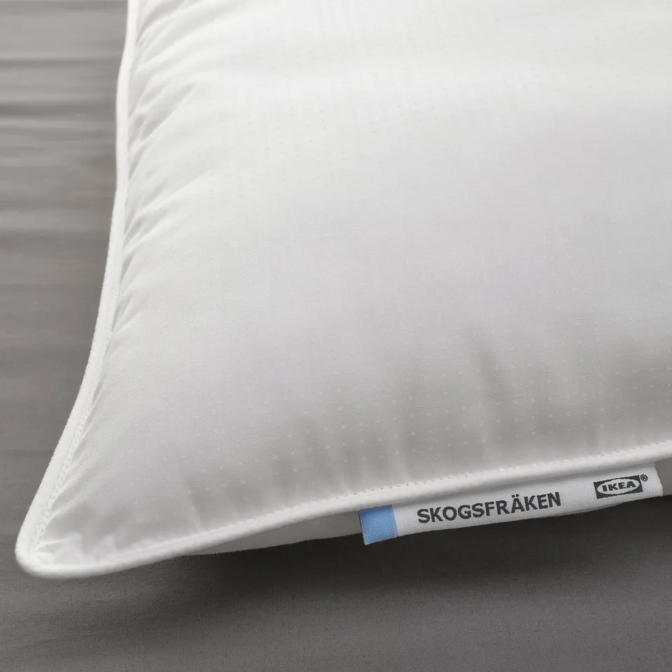Close-up of a soft, white SKOGSFRÄKEN pillow by IKEA, showcasing its smooth fabric texture and supportive design.