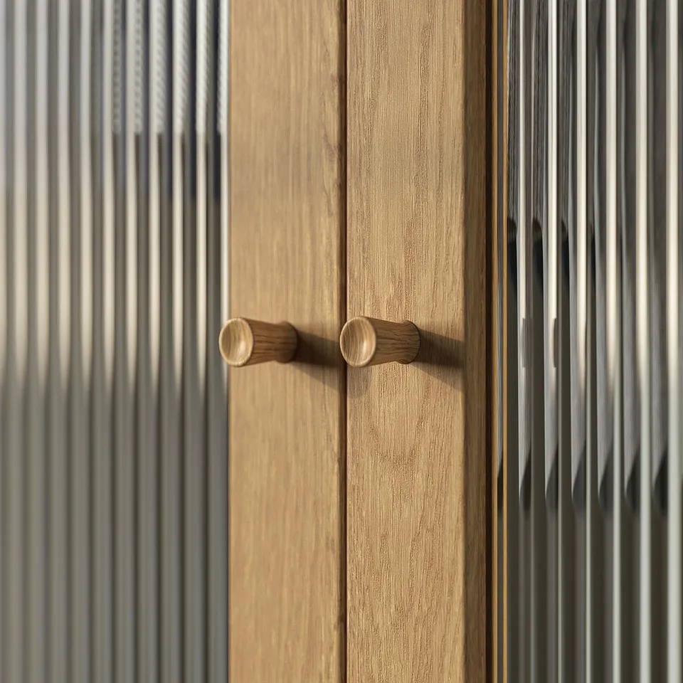 Wooden knobs on light-colored wooden door. Horizontal grooves and lines provide texture. Simple, rectangular shape.