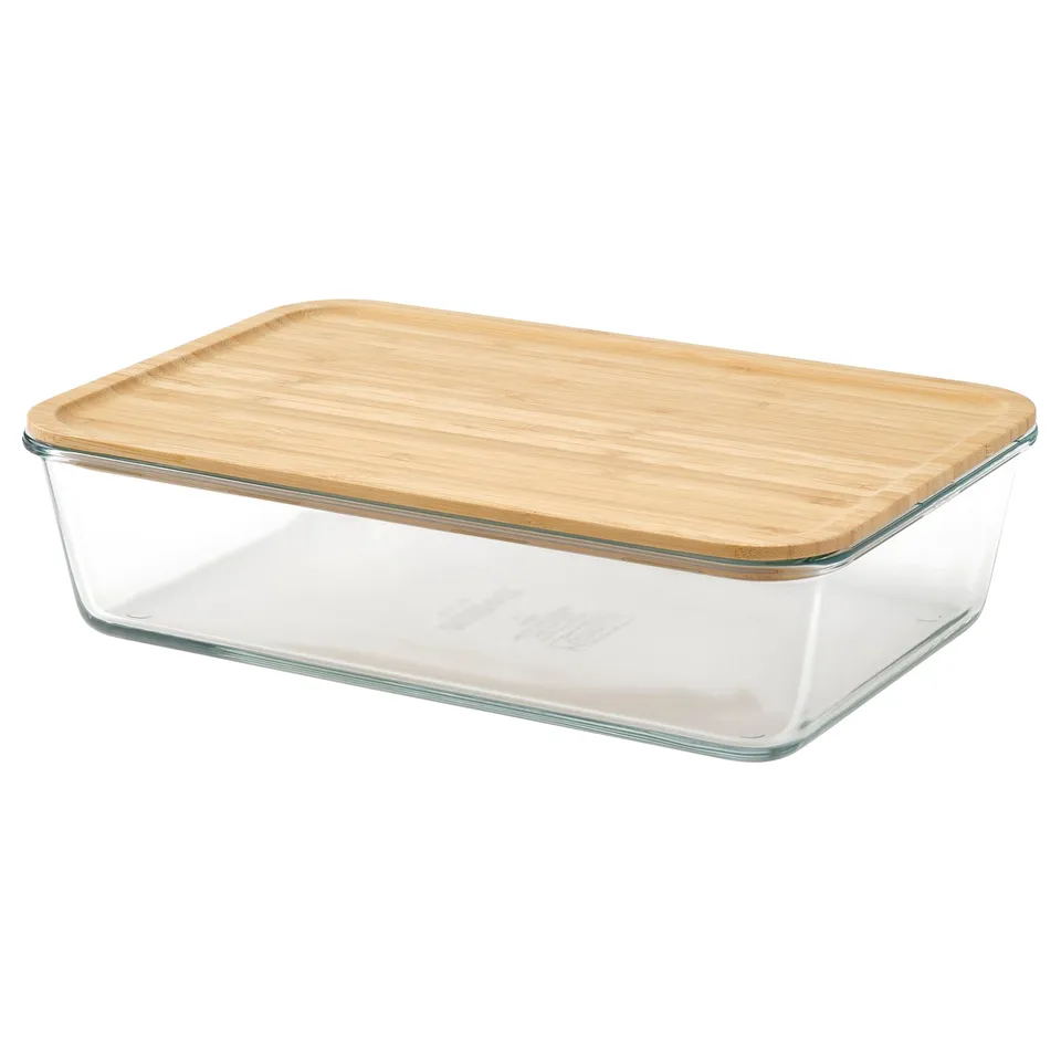 An IKEA 365+ glass container with a bamboo lid. Its clear and rectangular, ideal for storing food in the fridge.