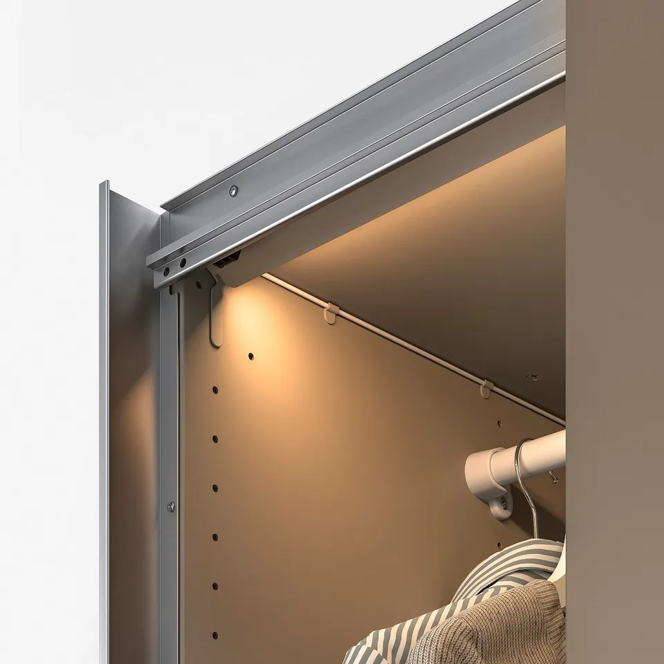 Modern wardrobe with built-in led sensor light, illuminating interior.