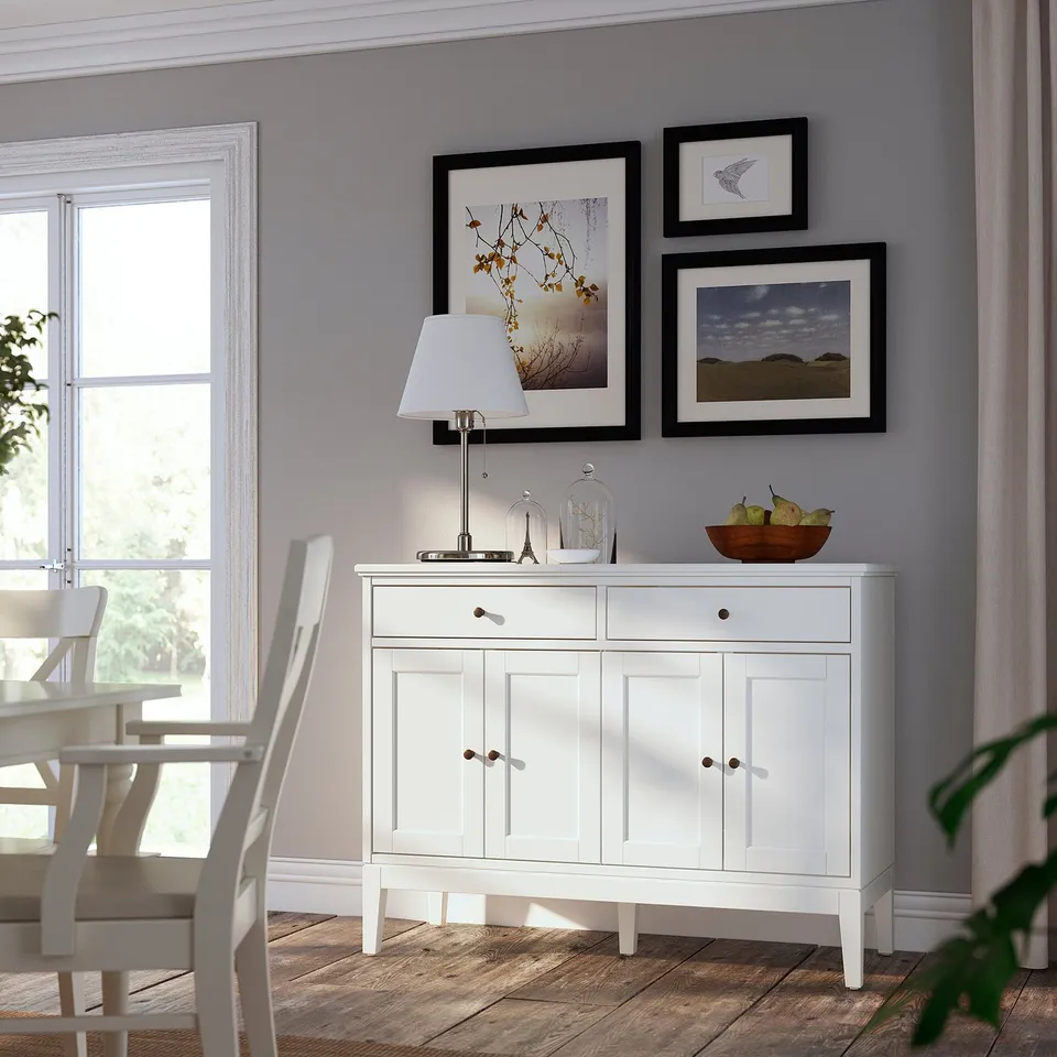 Bright dining room with white IDANÄS sideboard, large window, and art gallery wall.