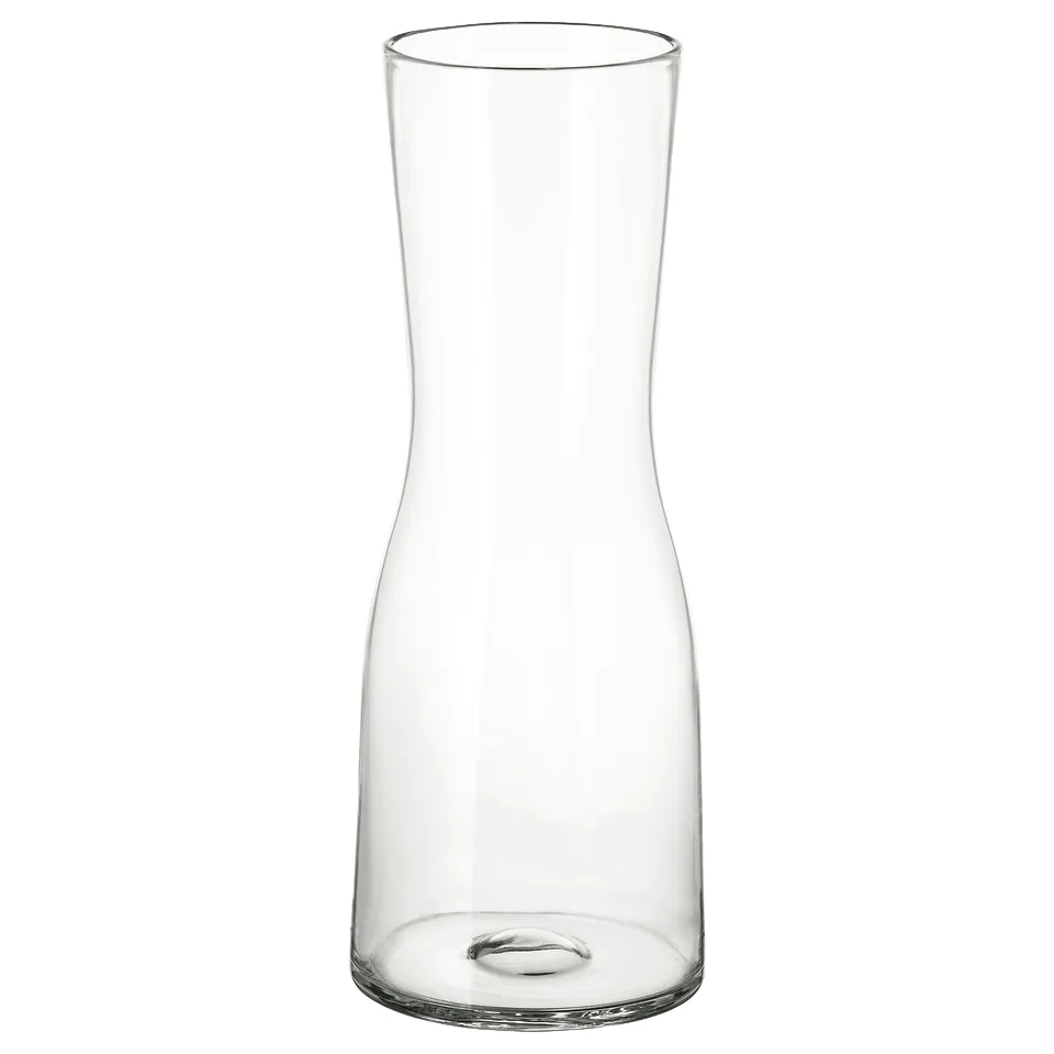 A TIDVATTEN glass vase. It is clear, sleek, and cylindrical with a narrow neck, designed for long-stemmed flowers.