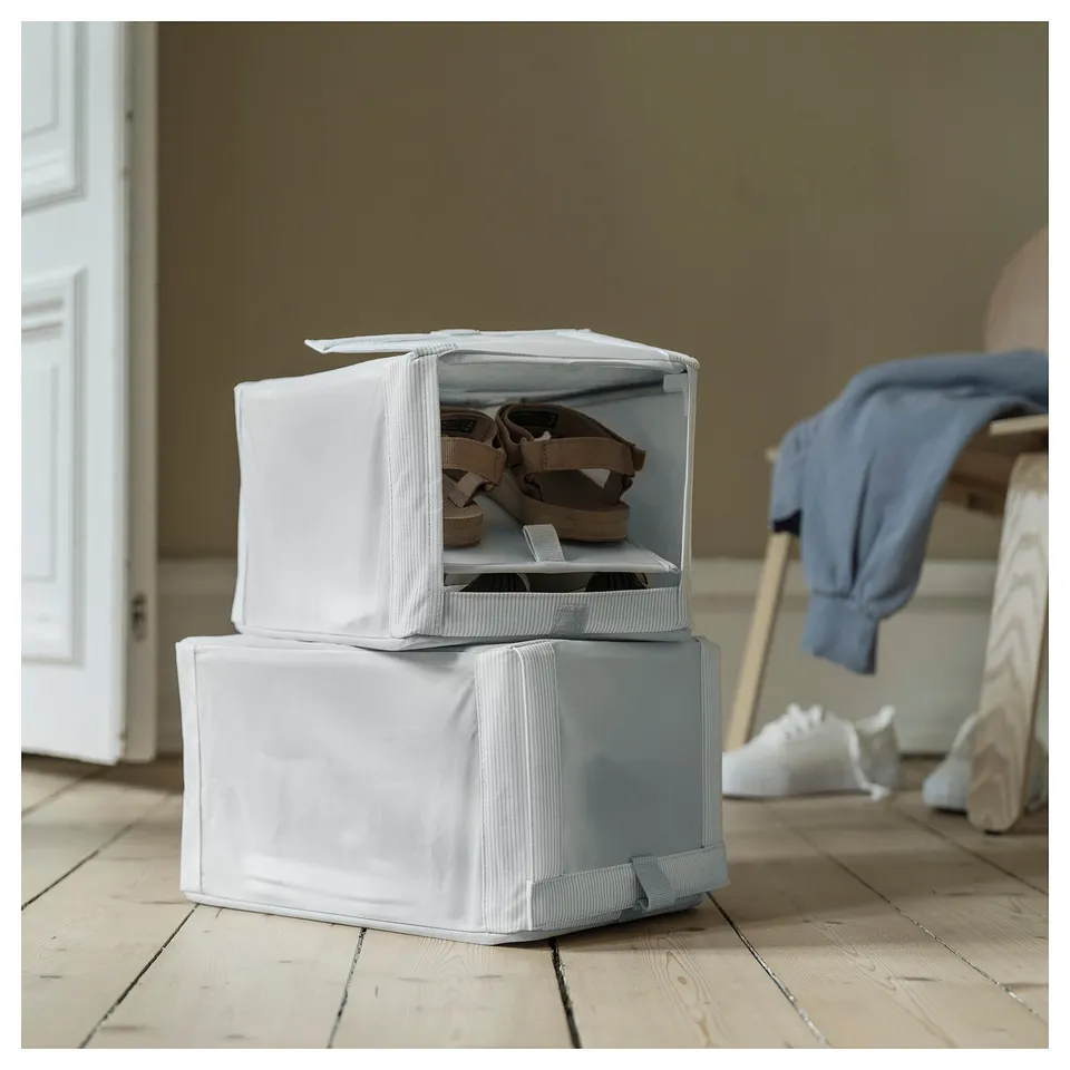 Stack of white fabric HEMMAFIXARE shoe boxes; one open shows shoes inside.