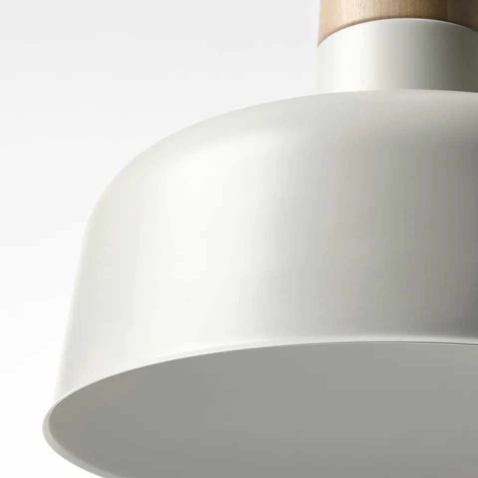 Close-up of a sleek, modern pendant lamp with a smooth, white metal shade and a natural wooden accent at the top.