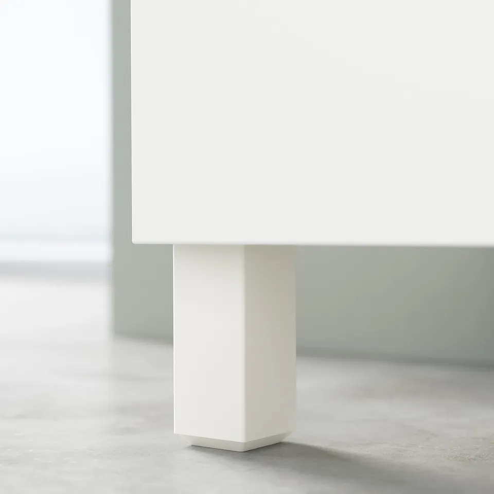 Minimalist white BESTÅ table leg, square shape, sleek design.