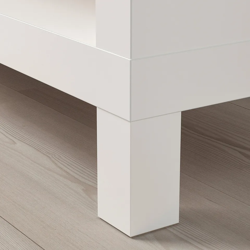 White modern tv stand on wooden floor. Clean lines, sturdy build.