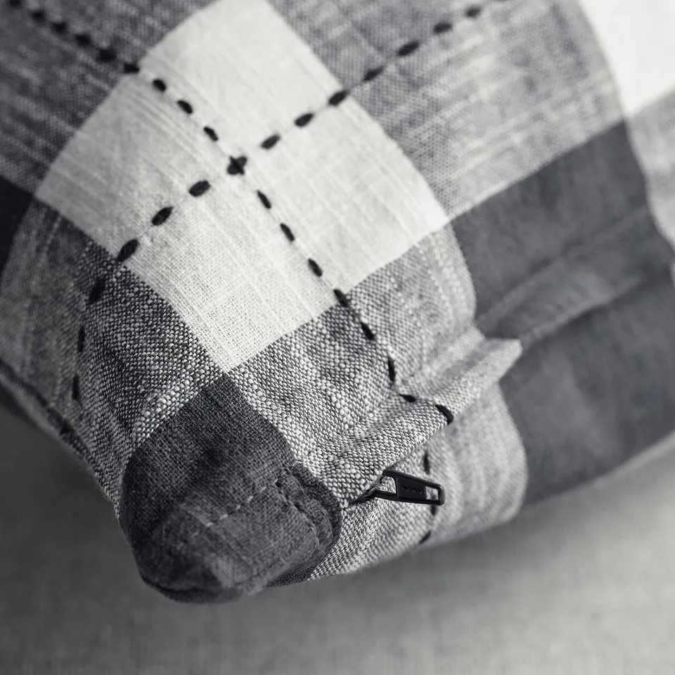 Close-up of chequered cushion cover with neat stitching and zip.
