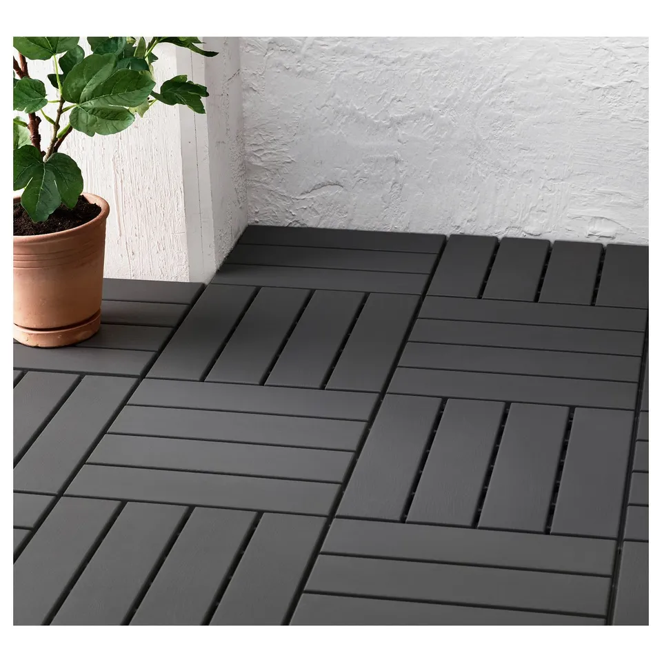 Grey interlocking patio tiles with potted plant on balcony.